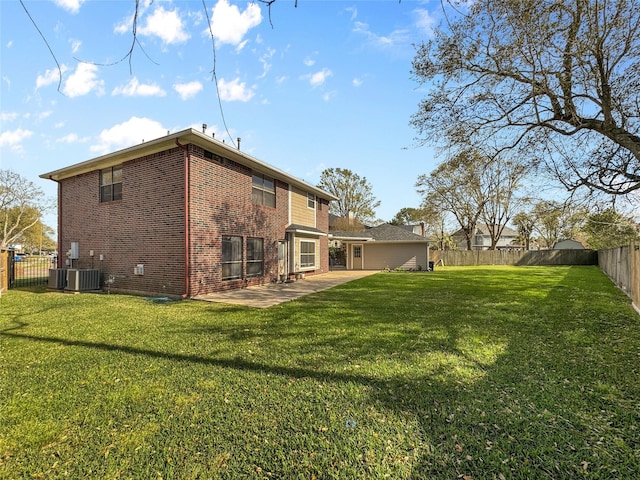 back of property with brick siding, a patio area, a yard, and a fenced backyard