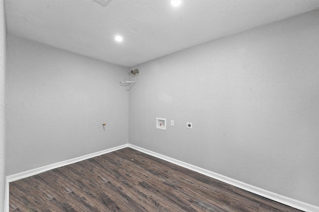 spare room featuring dark wood-style floors, a textured wall, a textured ceiling, and baseboards