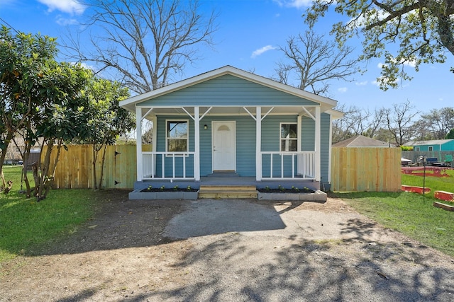 view of front facade with a front lawn, fence, and a porch