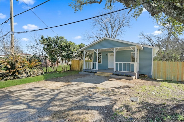 bungalow-style house featuring covered porch and fence