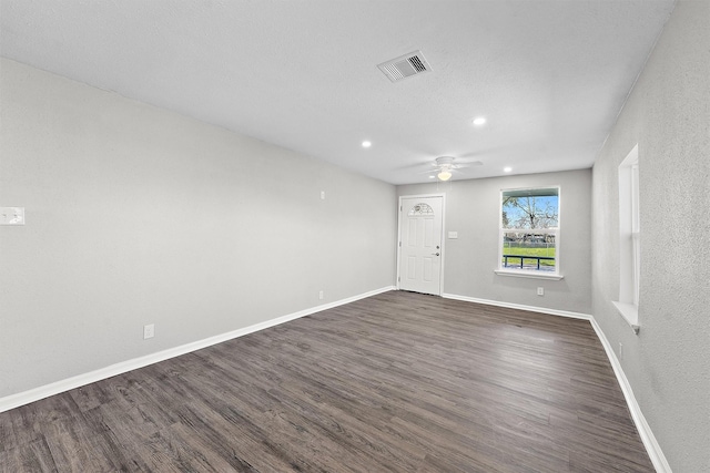 spare room with recessed lighting, a ceiling fan, visible vents, baseboards, and dark wood-style floors