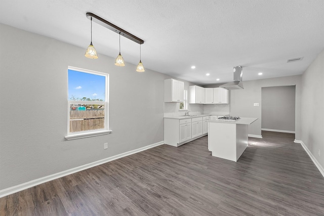 kitchen with dark wood-style floors, visible vents, island exhaust hood, and baseboards