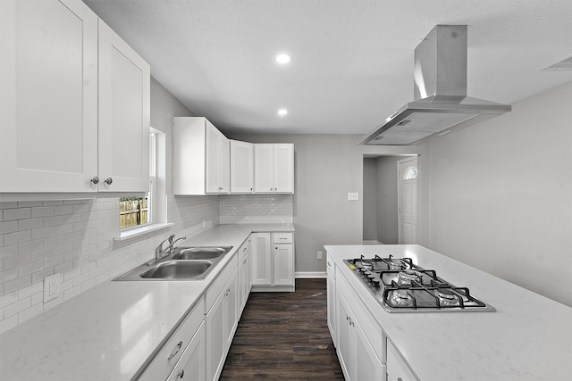 kitchen with dark wood-type flooring, a sink, white cabinetry, backsplash, and island exhaust hood