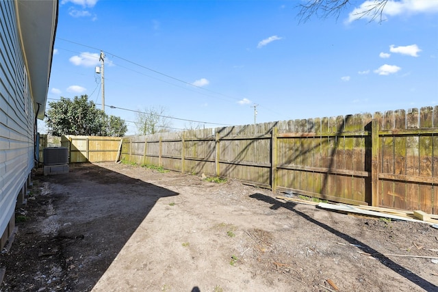 view of yard featuring fence and central AC unit