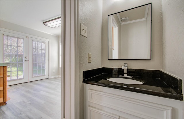 12710 Ashford Meadow Dr, Houston, TX 77082 - bathroom featuring a textured wall, wood finished floors, vanity, french doors, and crown molding