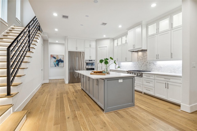 kitchen with appliances with stainless steel finishes, white cabinets, visible vents, and gray cabinetry