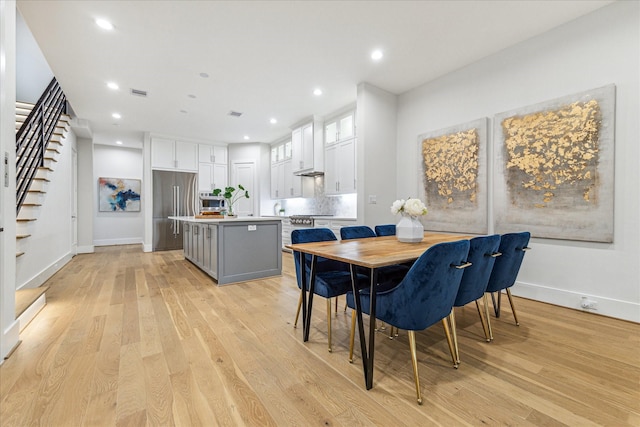 dining room featuring stairs, recessed lighting, baseboards, and light wood-style floors