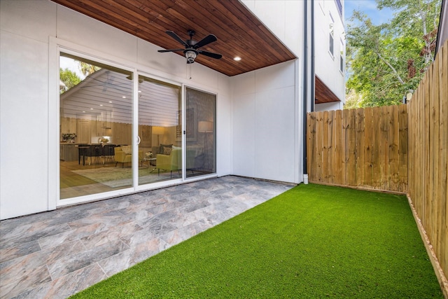 view of yard with a patio area, fence, and ceiling fan