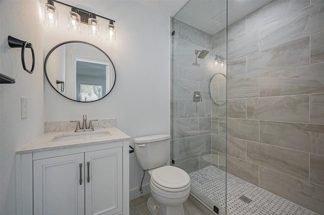 full bathroom featuring vanity, toilet, a walk in shower, and baseboards