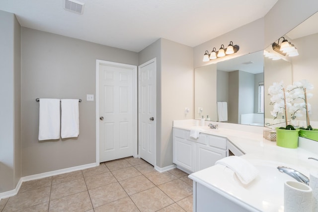 full bath featuring visible vents, baseboards, double vanity, tile patterned floors, and a sink