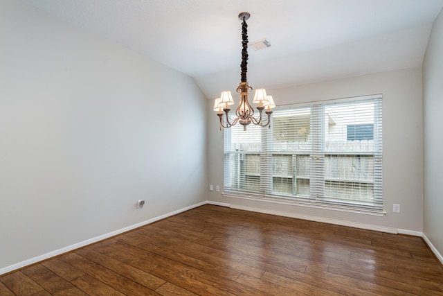 empty room with hardwood / wood-style flooring, baseboards, visible vents, and vaulted ceiling