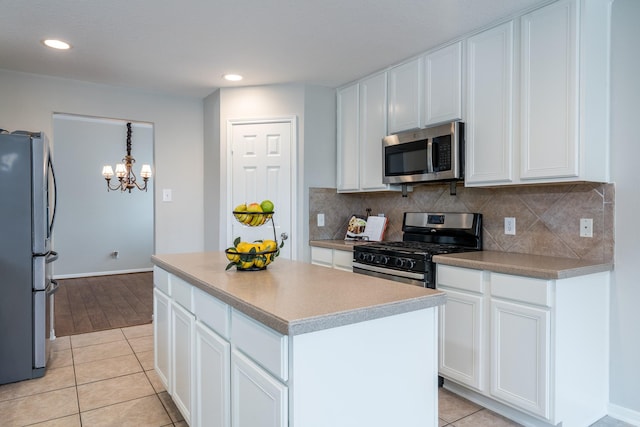 kitchen with white cabinets, light tile patterned floors, and appliances with stainless steel finishes