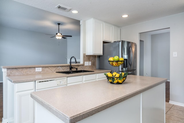 kitchen featuring visible vents, backsplash, stainless steel fridge with ice dispenser, dishwasher, and a sink