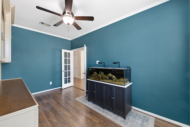 office space with dark wood-style floors, visible vents, crown molding, and baseboards