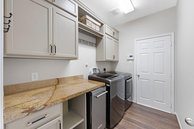 laundry room featuring dark wood-style flooring, washer and clothes dryer, visible vents, cabinet space, and baseboards