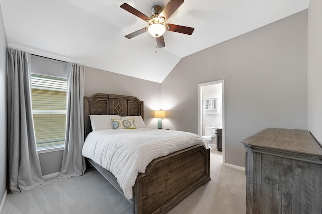 bedroom featuring ensuite bathroom, light colored carpet, a ceiling fan, baseboards, and vaulted ceiling