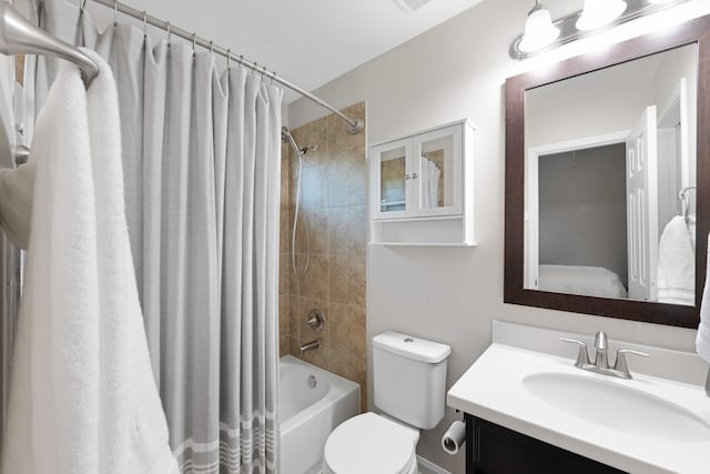 bathroom featuring toilet, shower / bath combo with shower curtain, and vanity