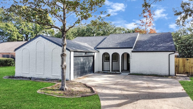 view of front of property with a garage, brick siding, concrete driveway, roof with shingles, and a front yard