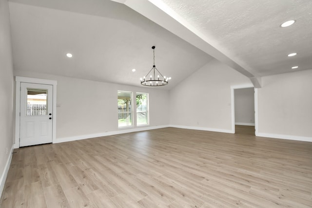 unfurnished living room with baseboards, lofted ceiling, light wood-style flooring, an inviting chandelier, and recessed lighting