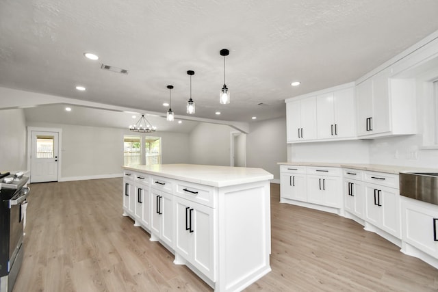 kitchen with light wood-style flooring, a kitchen island, stainless steel electric stove, pendant lighting, and recessed lighting