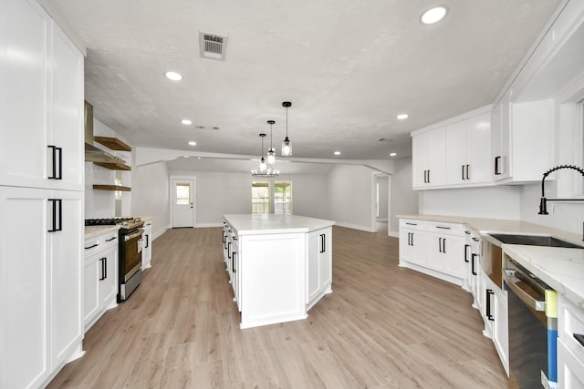 kitchen featuring appliances with stainless steel finishes, light wood-style floors, visible vents, and a sink