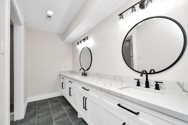 full bath with double vanity, tile patterned flooring, baseboards, and a sink