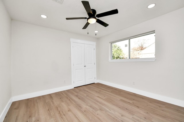 unfurnished bedroom featuring light wood-style floors, baseboards, a closet, and recessed lighting