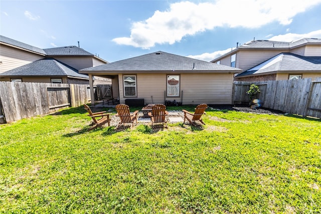 back of property featuring a fire pit, a lawn, and a fenced backyard