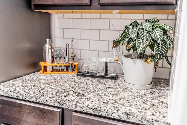 room details with light stone countertops and backsplash