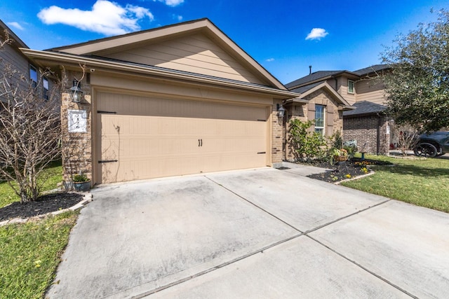 single story home with a garage, a front yard, brick siding, and driveway