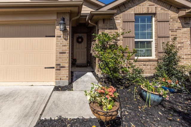 entrance to property with brick siding and an attached garage