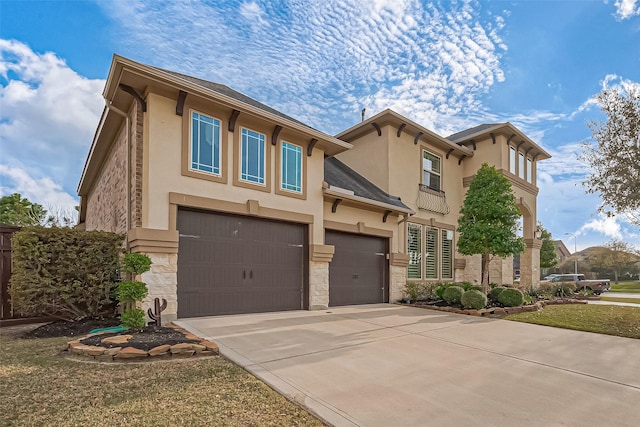 view of front of property featuring an attached garage, stone siding, concrete driveway, and stucco siding