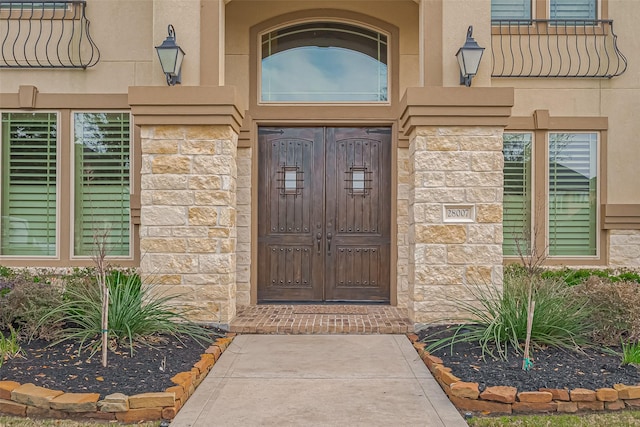 entrance to property with stone siding and stucco siding