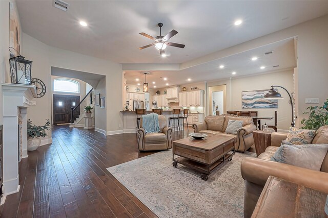 living area featuring stairs, dark wood finished floors, visible vents, and recessed lighting