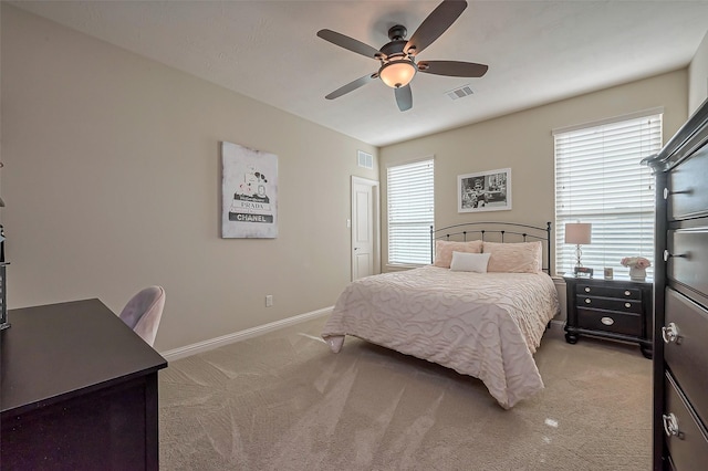 bedroom featuring baseboards, visible vents, and light colored carpet