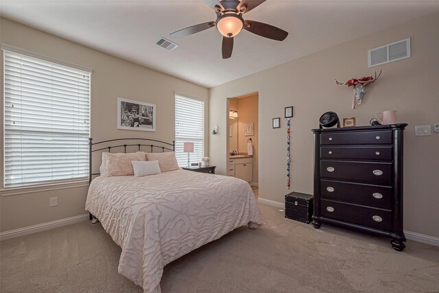 bedroom with baseboards, visible vents, and light colored carpet