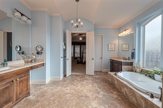 ensuite bathroom featuring crown molding, a healthy amount of sunlight, a sink, and a bath