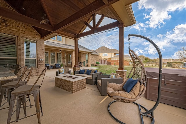 view of patio / terrace with outdoor dining area, an outdoor living space with a fire pit, and a hot tub