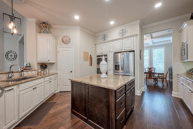 kitchen featuring dark brown cabinetry, stainless steel appliances, a sink, white cabinets, and dark wood finished floors