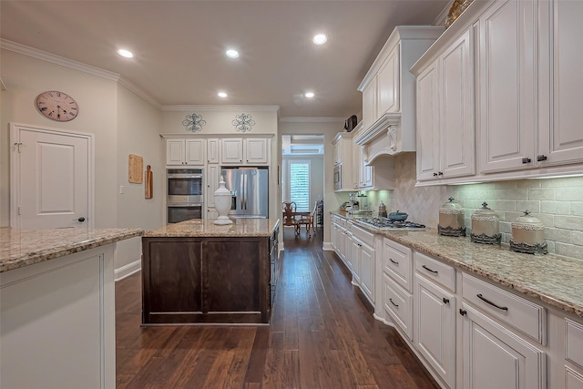 kitchen with decorative backsplash, dark wood-style floors, appliances with stainless steel finishes, ornamental molding, and white cabinetry