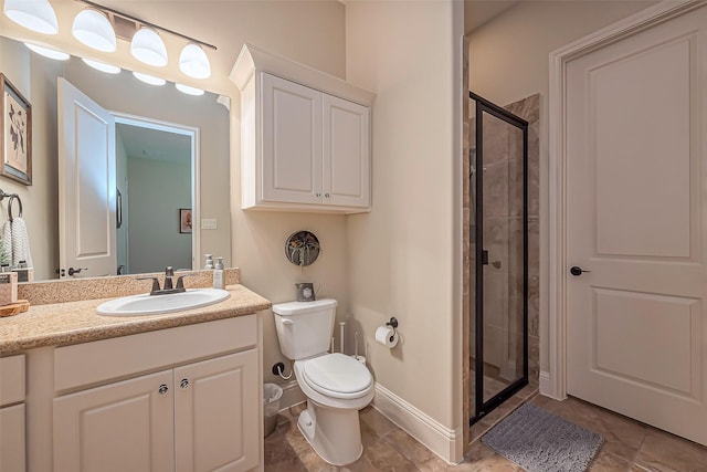 bathroom with baseboards, toilet, tile patterned flooring, vanity, and a shower stall