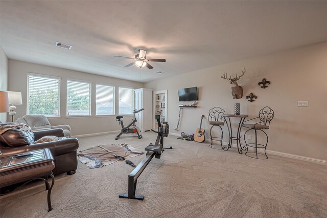 workout area with baseboards, carpet floors, visible vents, and a ceiling fan