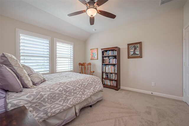 carpeted bedroom featuring ceiling fan, visible vents, baseboards, and vaulted ceiling