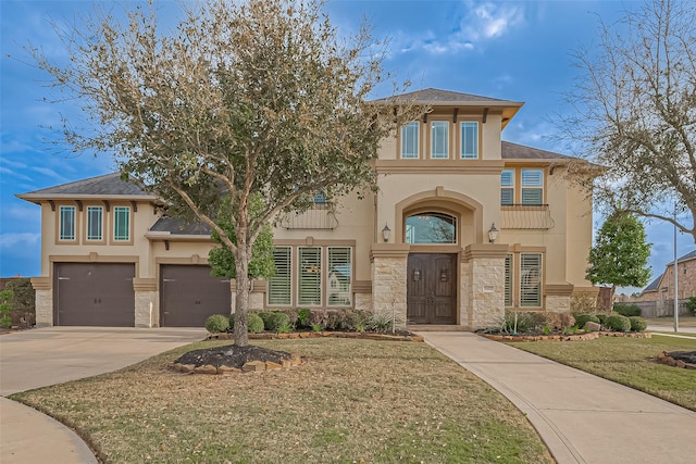 view of front of home featuring a front lawn, stone siding, concrete driveway, and stucco siding