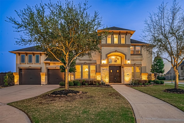 view of front of home with stucco siding, stone siding, concrete driveway, and a front lawn