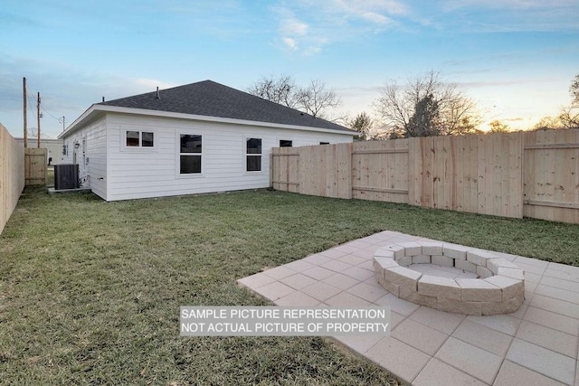 rear view of property featuring a patio, cooling unit, a yard, a fenced backyard, and a fire pit