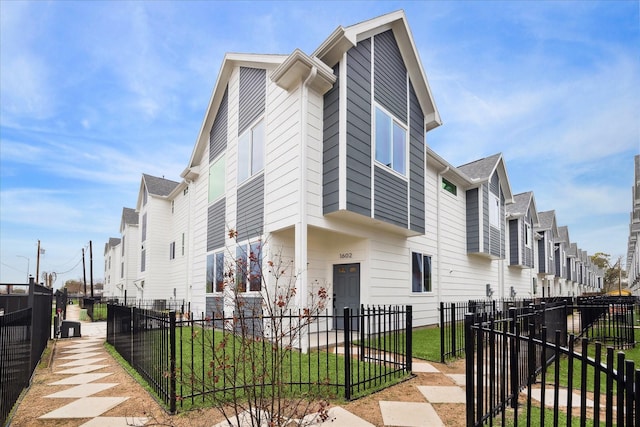 view of side of home with a fenced front yard and a residential view