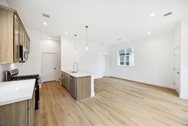 kitchen featuring stainless steel appliances, light wood finished floors, a sink, and visible vents