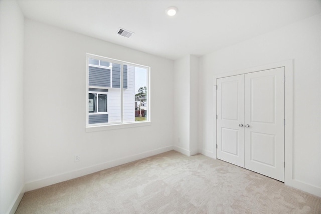 unfurnished bedroom featuring carpet, visible vents, and baseboards