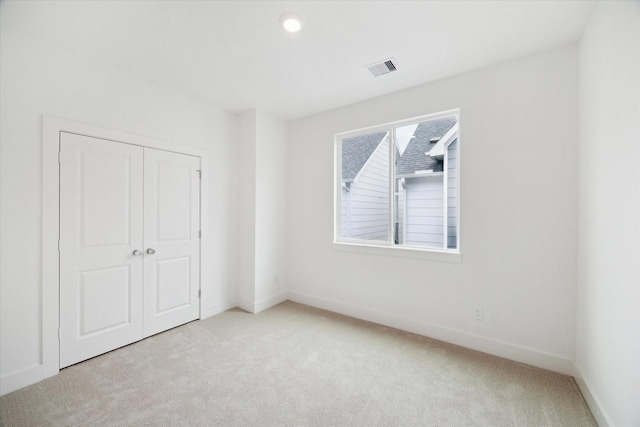 unfurnished bedroom featuring visible vents, a closet, baseboards, and carpet flooring